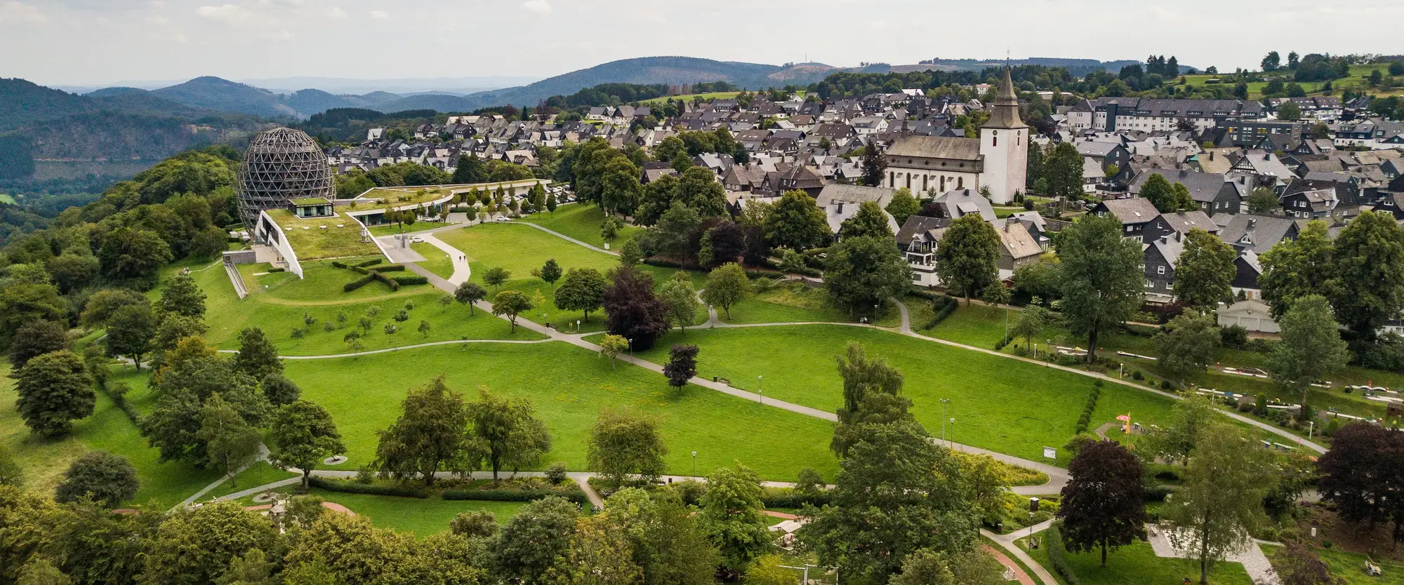 Drohnenaufnahme vom Winterberger Kurpark mit dem Hotel Oversum und einem Teil der Stadt.